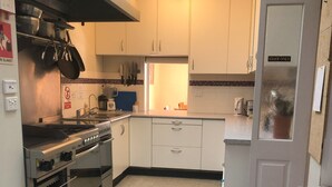 A kitchen with white cabinets, a stove, and a sink.