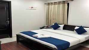 Een keurig opgemaakt slaapkamer met een bed, nachtkastje en een plafondventilator.