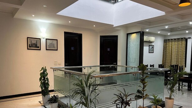 Een ruime binnenzone met glazen balustrade, potplanten en dakraam.
