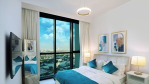 Une chambre d’hôtel moderne dotée d’un grand lit, de deux tables de chevet, d’un miroir et offrant une vue sur la ville grâce à de grandes fenêtres du sol au plafond.