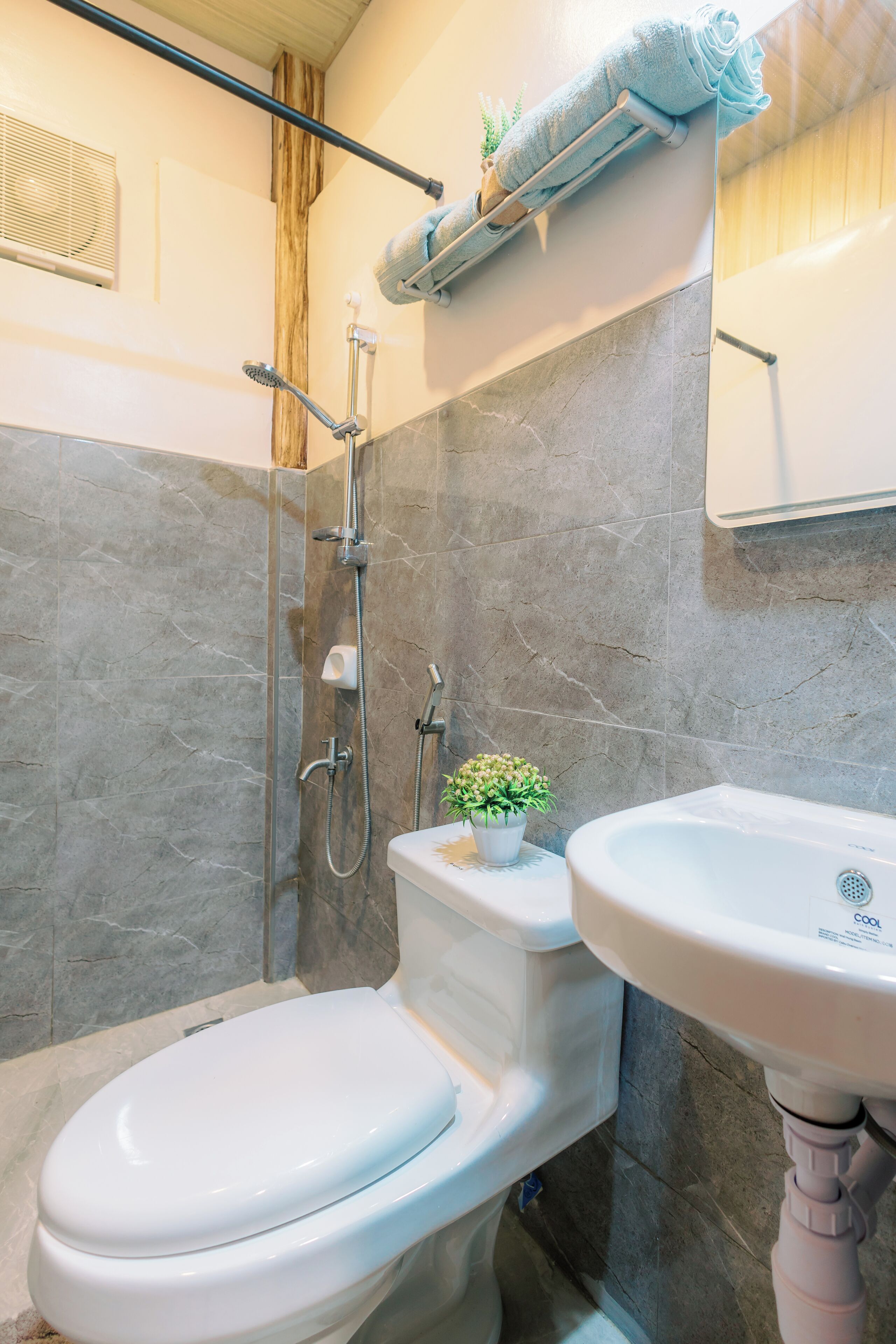 A bathroom with a toilet, a shower, and a sink.
