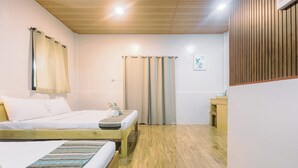 A room with two beds, wooden flooring, a small bedside table with a lamp, and a window with curtains. - BUSAI DREAM FALLS RESORT (Sevilla)