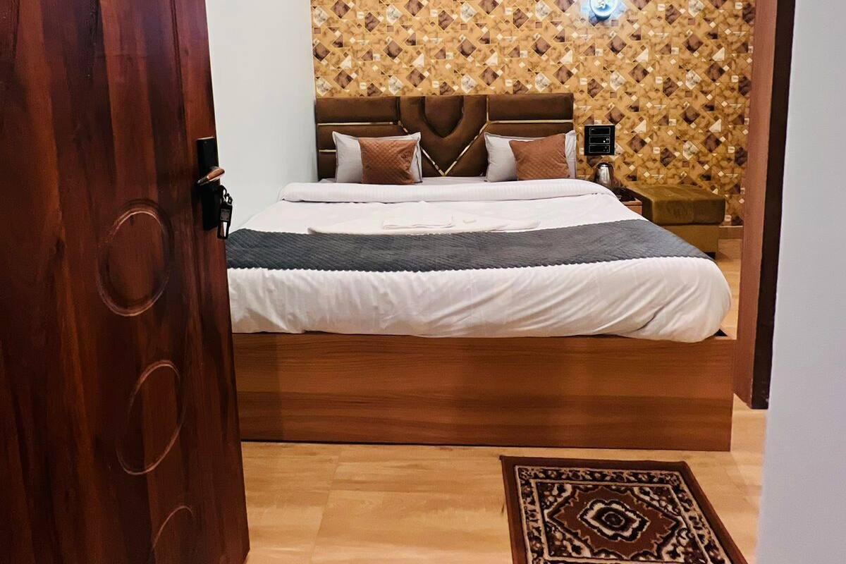 A bedroom with a wooden bed, a ceiling fan, and a patterned wall.