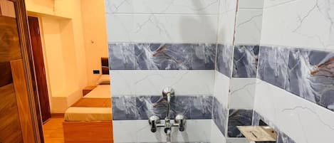 A bathroom with a shower, tiled walls, and a wooden floor.