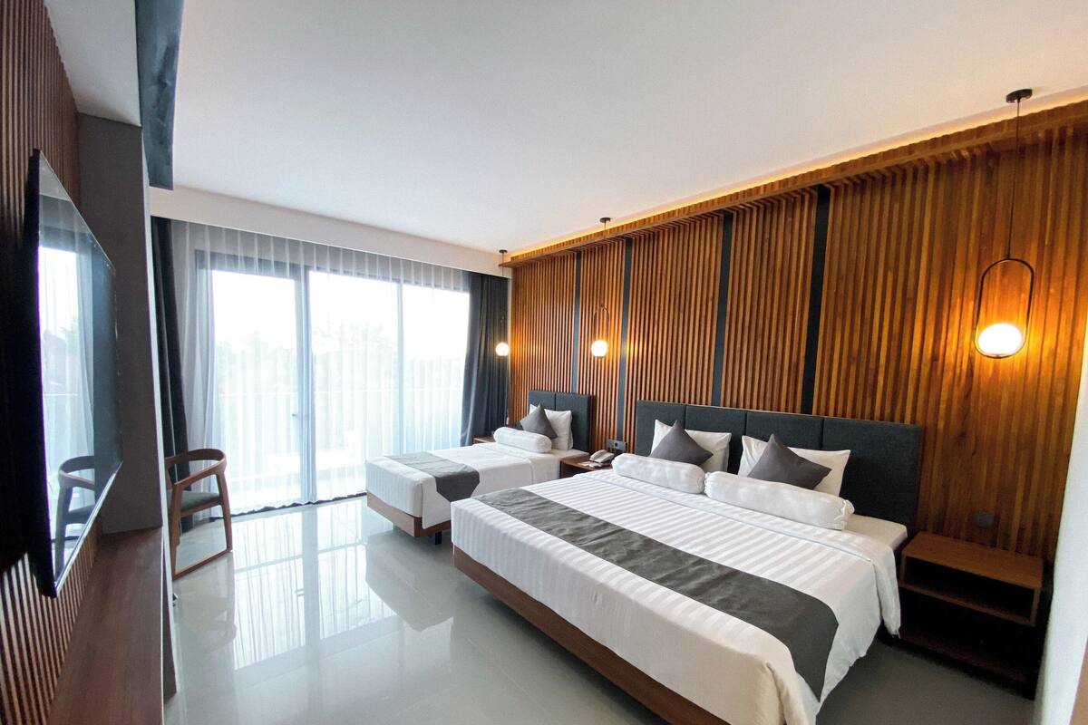 A modern hotel room with a large bed, a desk, and a chair.