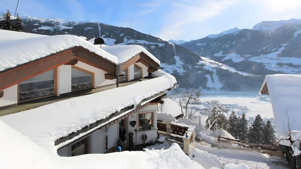 A snow-covered chalet with a balcony, a wooden roof, and a view of snow-capped mountains. - Apartment 'Melissa' with Mountain View, Balcony and Wi-Fi (Zellberg)