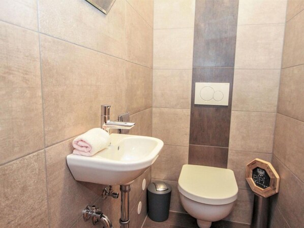 A bathroom with a sink, toilet, and trash can. - Apartment 'Melissa' with Mountain View, Balcony and Wi-Fi (Zellberg)