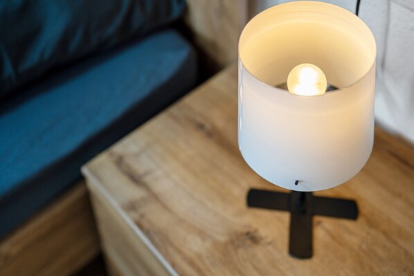 A white table lamp with a spherical light bulb on a wooden nightstand. - Apartment 'Wohnung 3' with Balcony and Wi-Fi (Rheinhausen)
