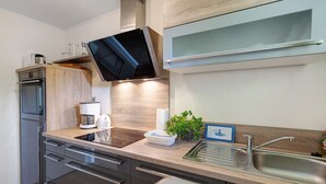 A modern kitchen with a built-in oven, microwave, and a large sink. - Apartment 'Hoper Mühle' with Balcony and Wi-Fi (Sankt Michaelisdonn)