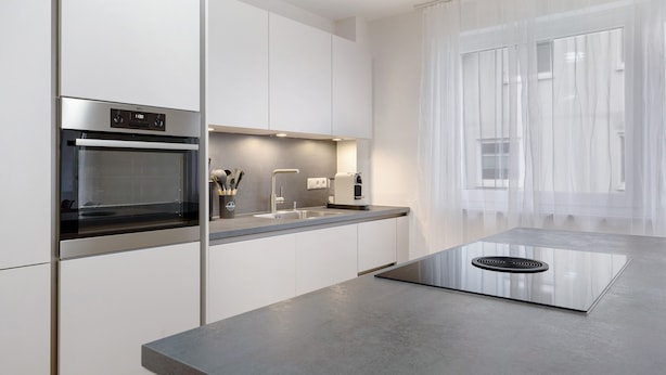 Una cocina moderna con horno empotrado, pileta y estufa.