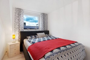 A bedroom with a bed, a nightstand, a window, and curtains. - Apartment Aufm Weinberg 1 with Wi-Fi (Schwandorf)