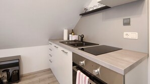 Una cocina moderna con estufa integrada, un lavamanos y una encimera.