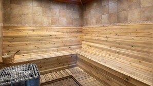 Una sauna con bancos de madera, una rejilla metálica y una pared de azulejos.