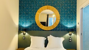 A double bed with white linens, two pillows, and a bedside table with a lamp. - FRATERNITY-HOTEL (Paris)
