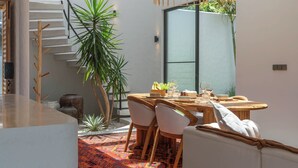 Un comedor moderno con una mesa de madera, sillas y un tapete rojo estampado.