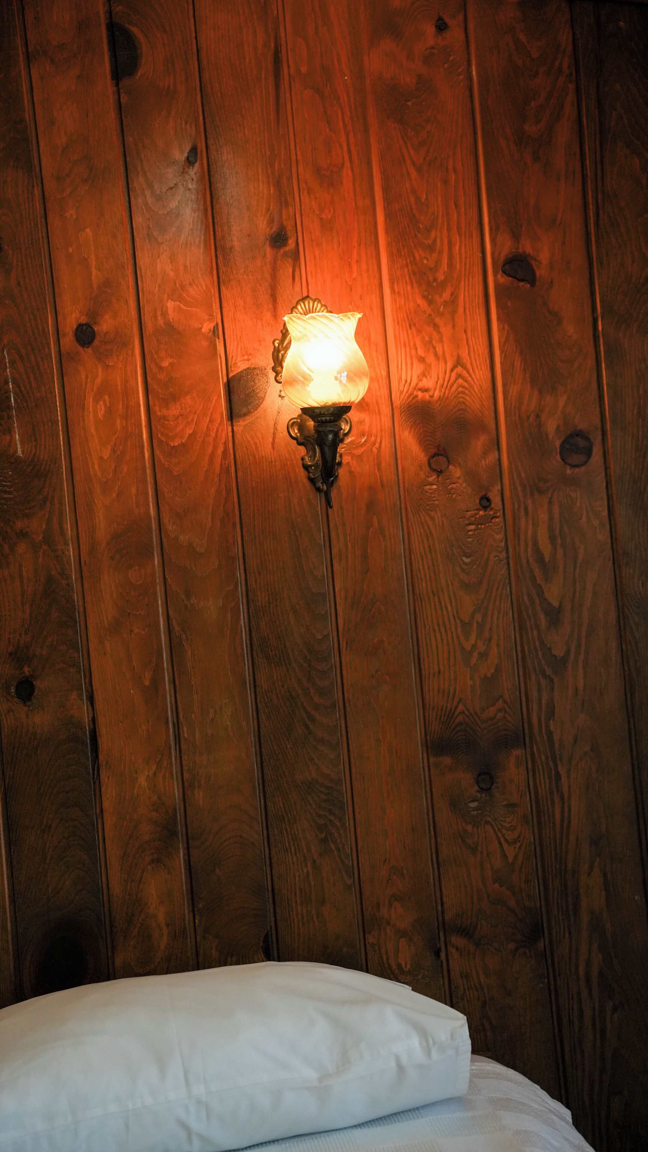 A wooden wall with a wall-mounted light fixture.