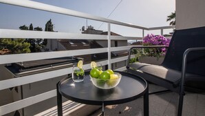A balcony with a table, a chair, and a bowl of fruit. - Sun Spalato Firule (Split)