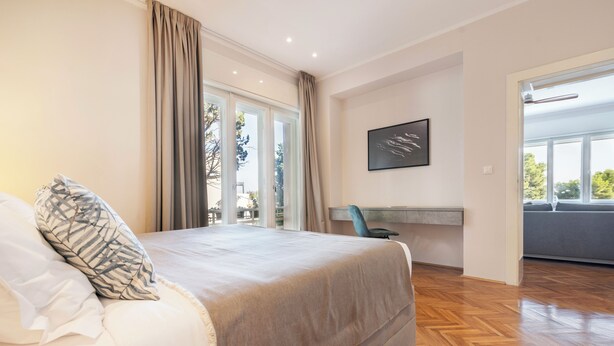 A bedroom with a bed, a desk, and a view of the outdoors. - Sun Spalato Firule (Split)