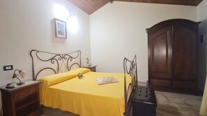A bedroom with a bed, bedside table, lamp, and wardrobe. - Double room 1 with separate entrance (Cariati)