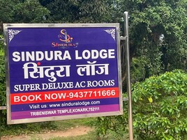 A sign for Sindura Lodge advertising super deluxe AC rooms.