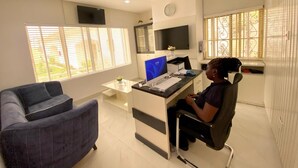 A modern office with a desk, computer, and a couch. - Am Place Luxury Apartments (Abuja)