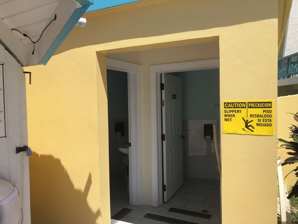 Entrada de hotel con un letrero de precaución por piso mojado.