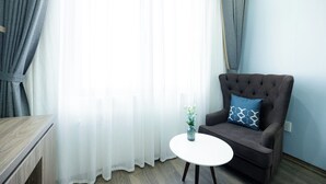 Ein modernes Wohnzimmer mit einem braunen Sessel, einem weißen Tisch und einem Blumenstrauß.