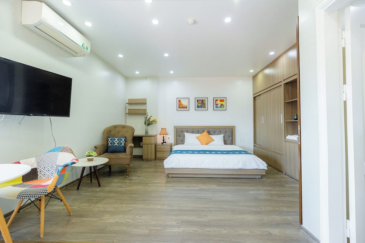 Une chambre d’hôtel moderne équipée d’un lit, d’un bureau, d’une chaise et d’un téléviseur.