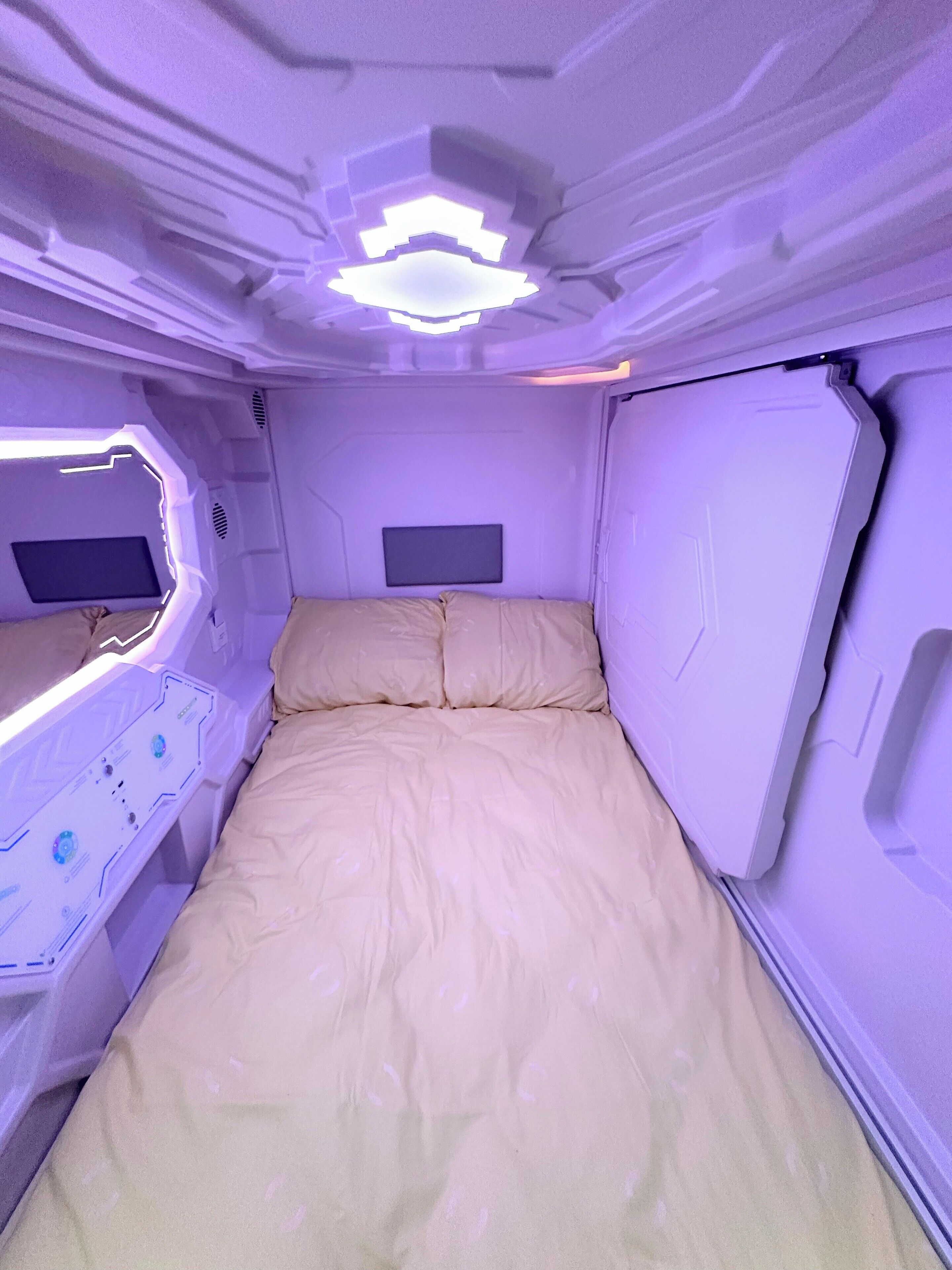A room with a bed, a control panel, and a monitor.