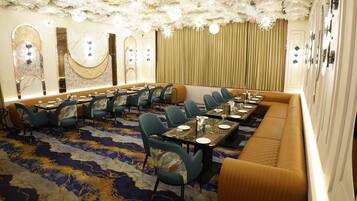 A conference room with a long table, multiple chairs, and a cushioned bench.