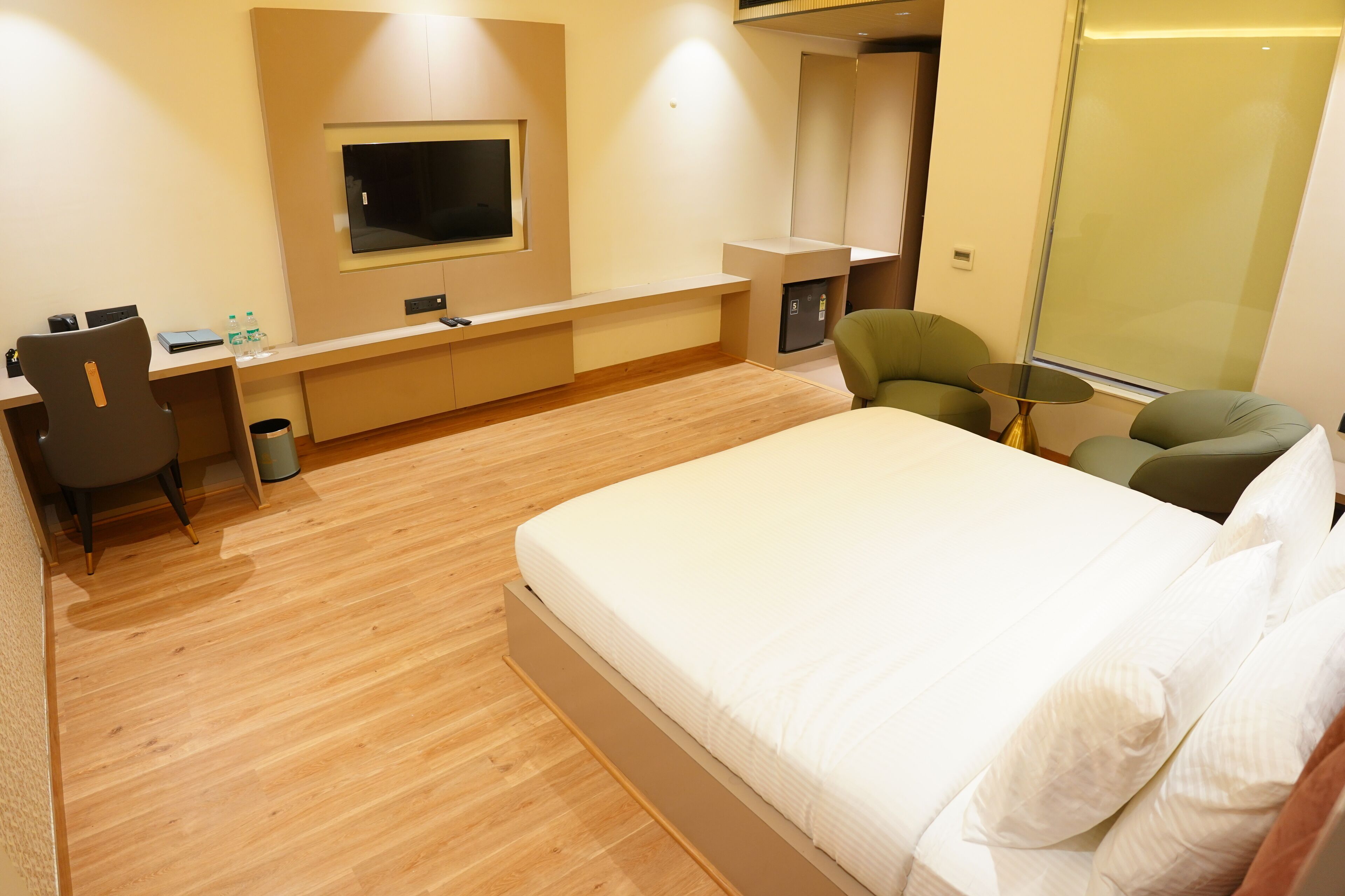 Een hotelkamer met een bed, bureau, stoelen en een televisie.