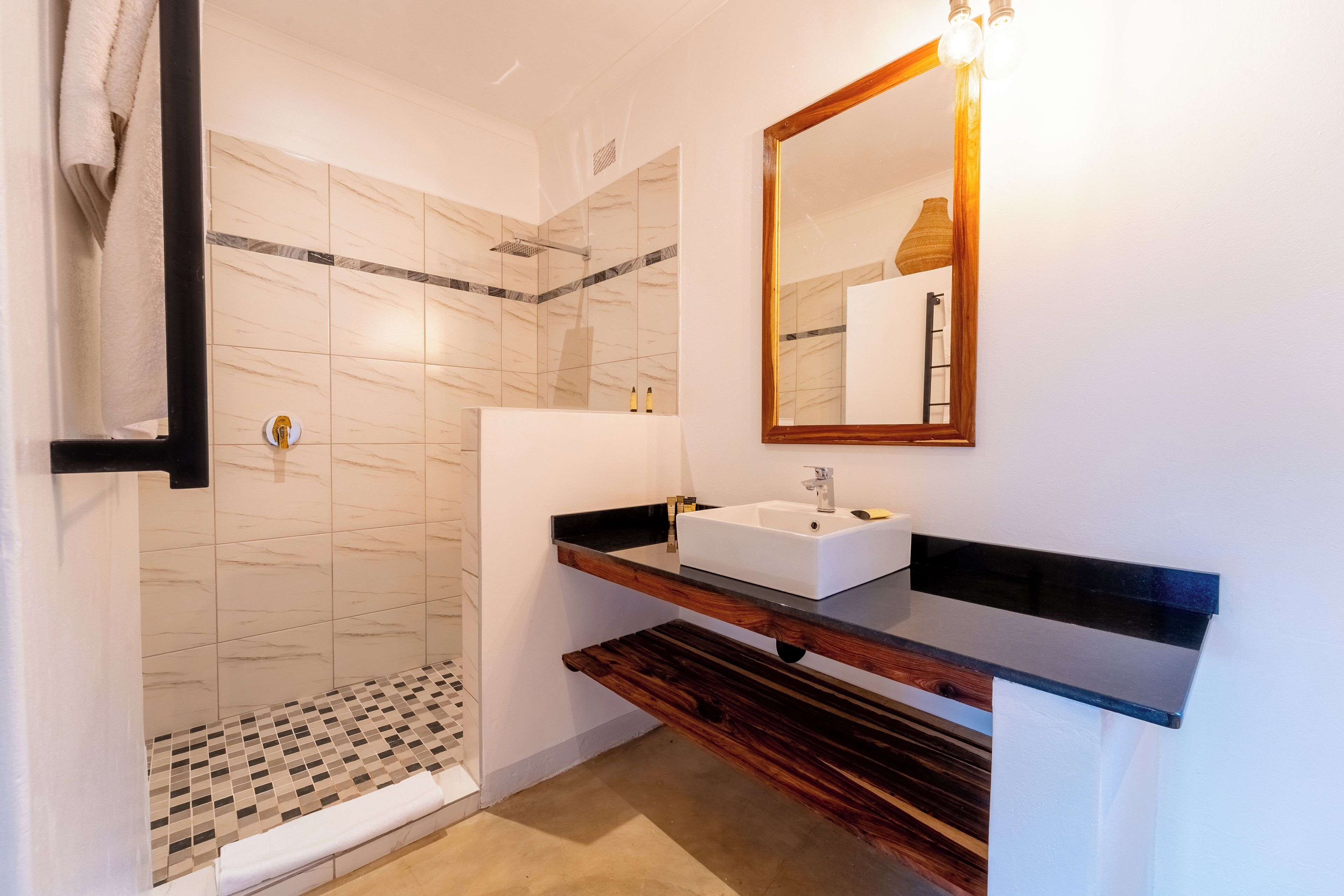 Een moderne badkamer met een douche, wastafel en spiegel.