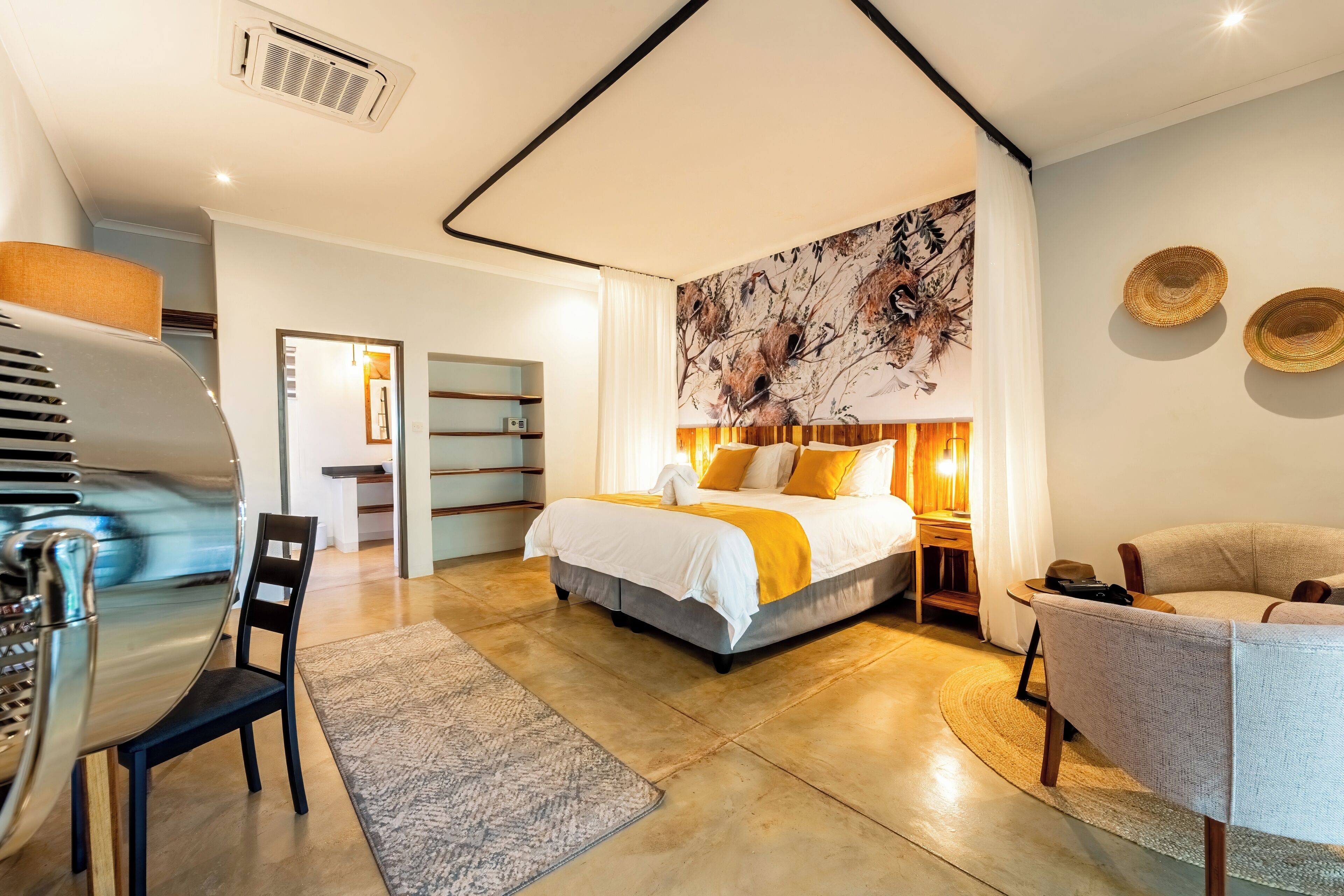 Een moderne slaapkamer met een groot bed, een bureau en een stoel.