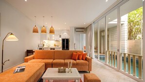 Een moderne woonkamer met een modulaire bank, een salontafel en hanglampen.