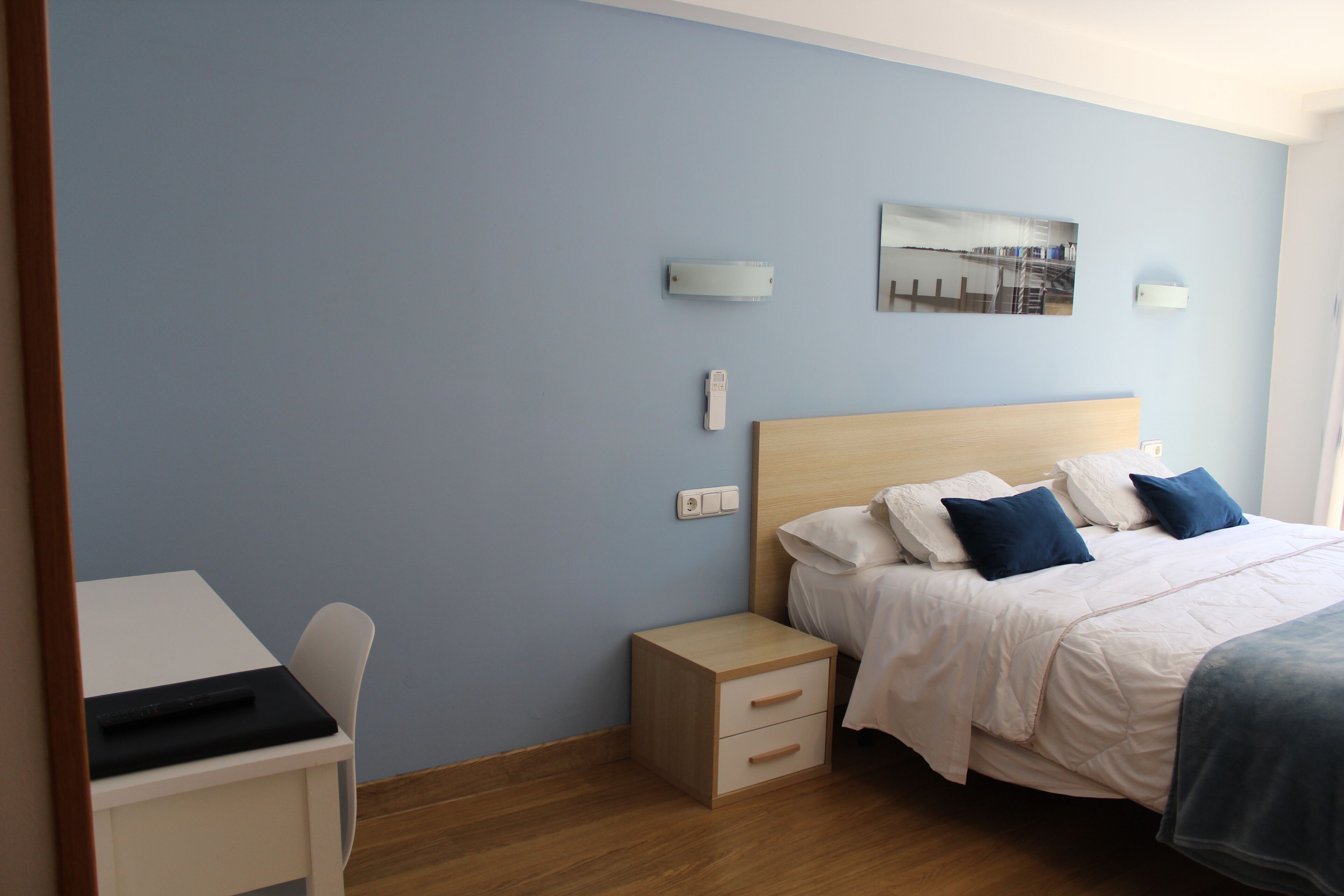 Una camera da letto con un letto, un comodino e una scrivania.