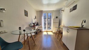 A compact kitchen with a dining area, a refrigerator, a sink, and a small table with chairs. - Pension Joakina (San Sebastián)