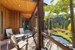 A wooden deck with outdoor seating, a view of a forested valley, and a small stream. - Mill Creek 201 (Keystone)