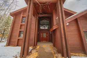 A wooden cabin with a central entrance, large windows, and a sloped roof. - Bryant Home 1826 (Keystone)