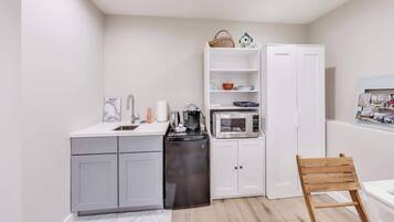 Een koelkast, een magnetron, een koffiezetapparaat/waterkoker, eettafels