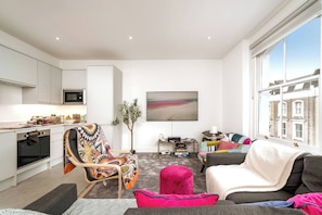 Relax in this stylish living room with a sofa, chair, and coffee table, offering a city view.