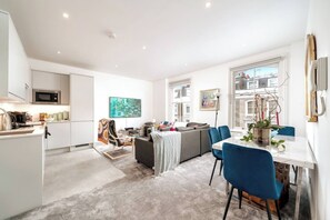 A modern apartment with a kitchen, dining area, and living space. - Spacious 4-bedroom, 2-bathroom duplex in Earl’s Court/Chelsea, just 8 minutes’ walk to the tube. Close to Westfield, Holland Park, museums, cafés, and restaurants. Stairs required to access the unit — perfect for families or groups exploring London. (London)