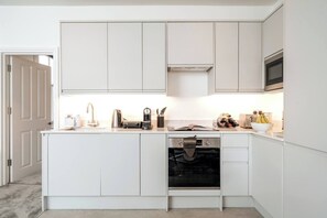 Enjoy cooking in this well-equipped kitchen with a central island, oven, and stainless steel range hood.