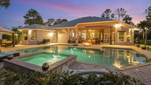 Une maison moderne dotée d’une piscine, d’un espace salon extérieur et d’un patio couvert.