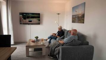 Classic-Apartment, Kanalblick | Wohnbereich | 43-Zoll-Flachbildfernseher mit Satellitenempfang