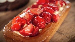 Een dessert met aardbeien op een gebakje.