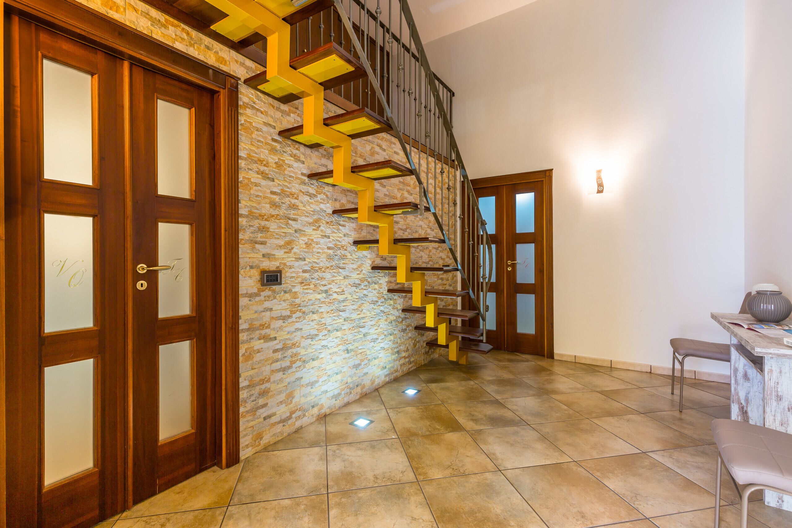 A staircase with wooden steps and a stone wall.