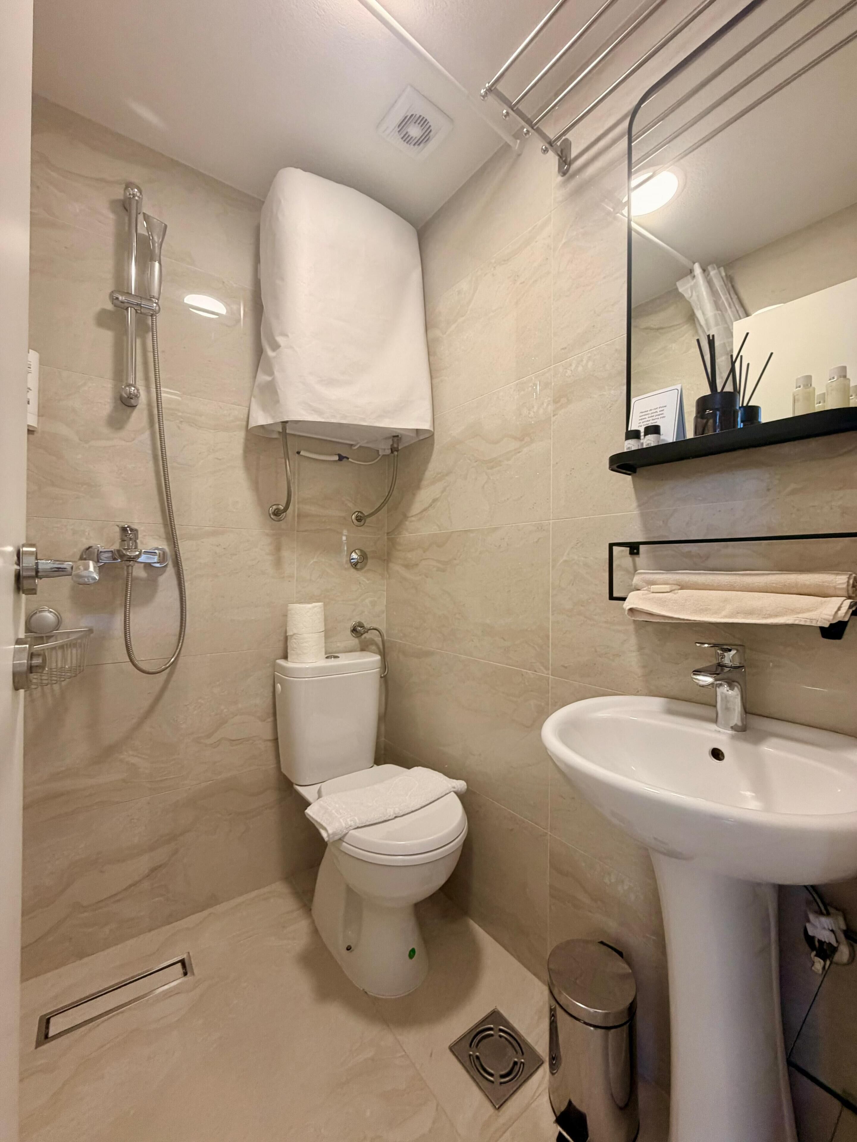 Un baño moderno con inodoro, bidé, ducha y lavamanos.