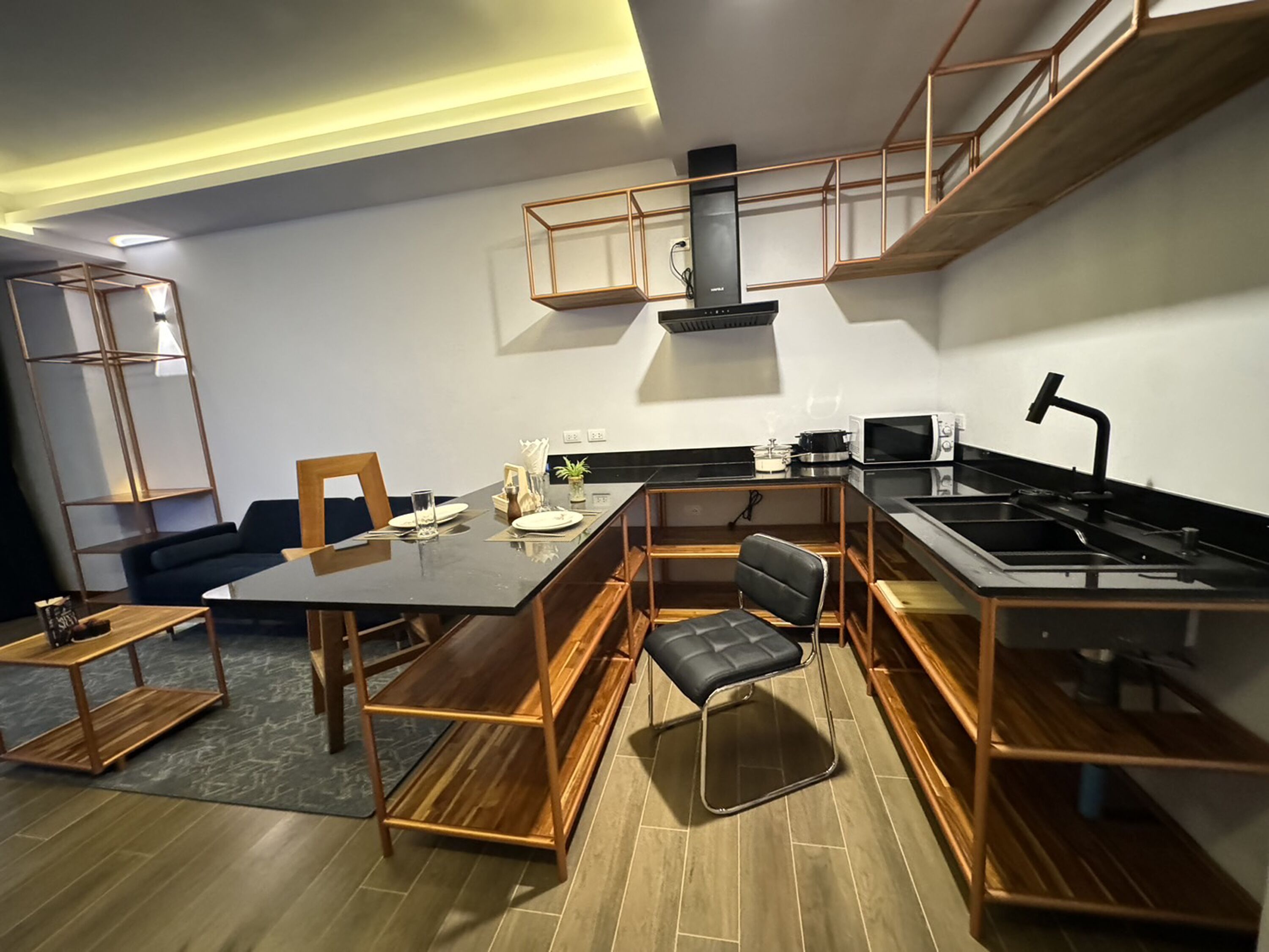 A modern kitchen with a dining area, built-in appliances, and a loft-style seating area.