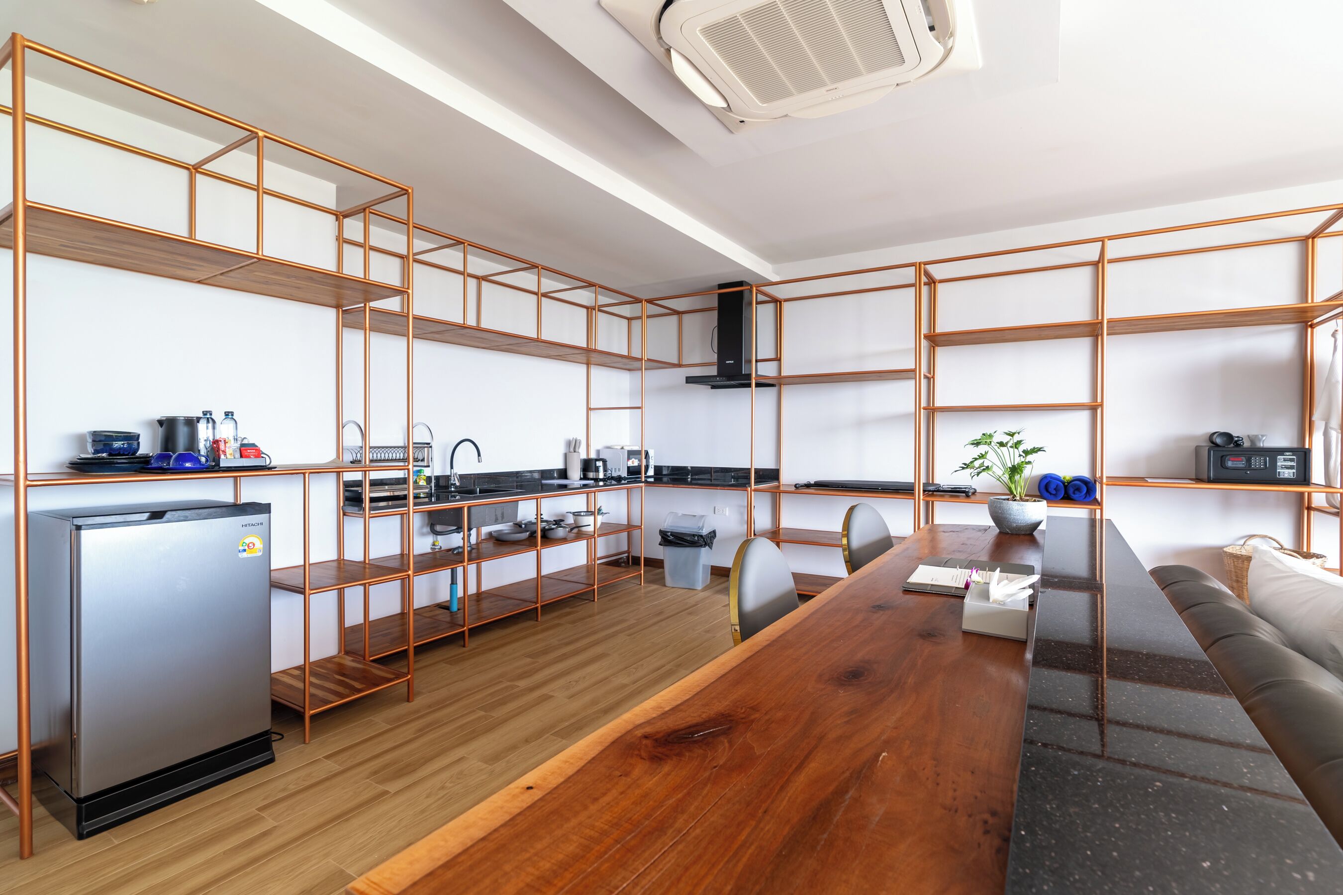 Una cocina moderna con una mesa de comedor de madera, estantes empotrados y un refrigerador.