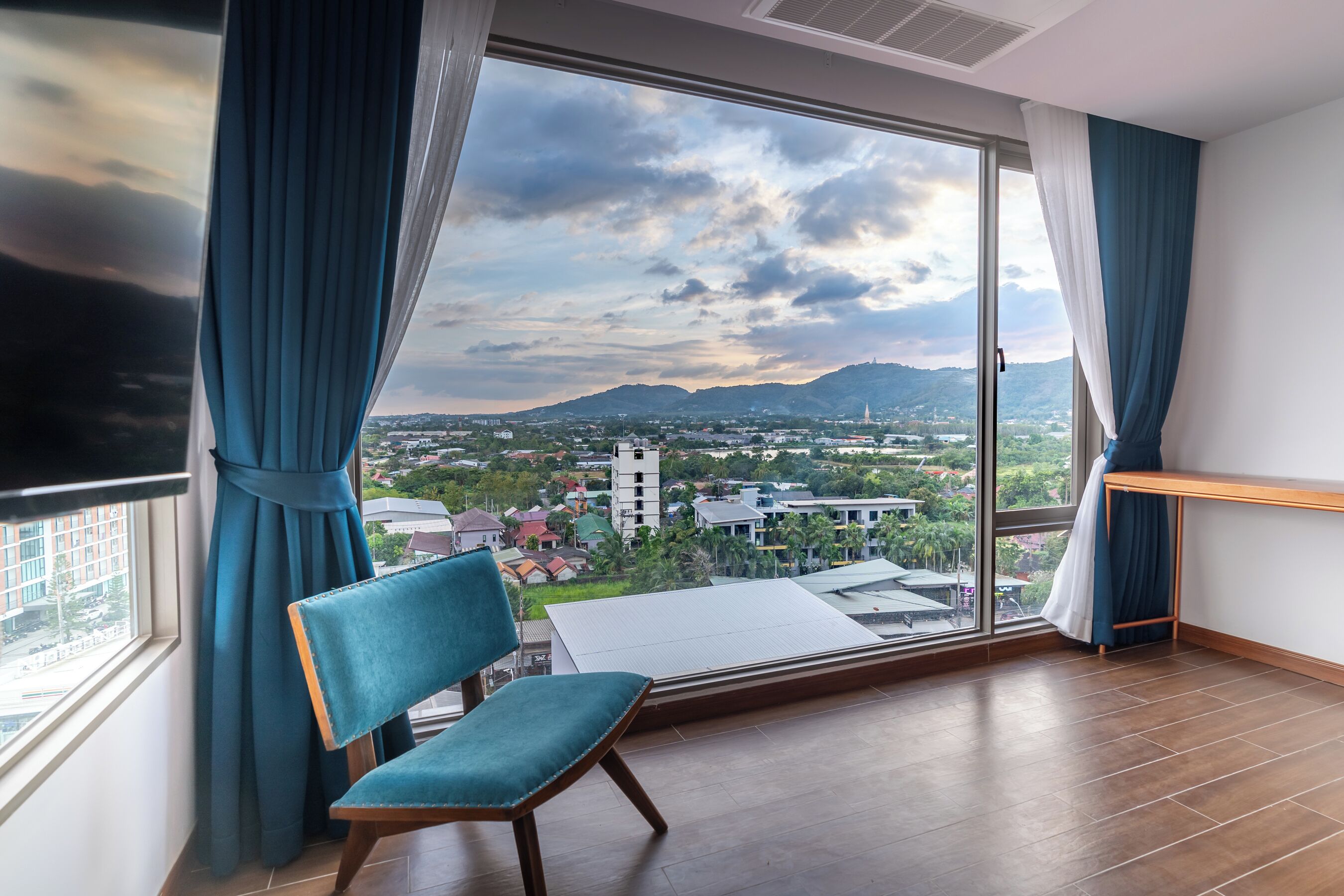 A room with a large window, a chair, and a table.